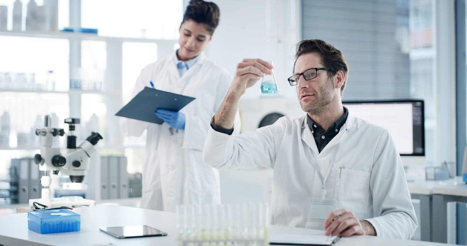Two scientists inspecting a peptide sample during quality control